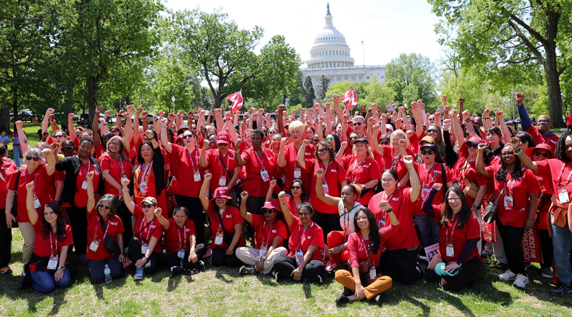 Large group of nurses outside Capitol building in Washington, D.C. with raised fists