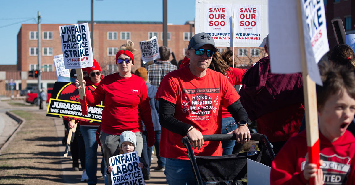Nurses on strike line holding signs "Unfair Labor Practice Strike"