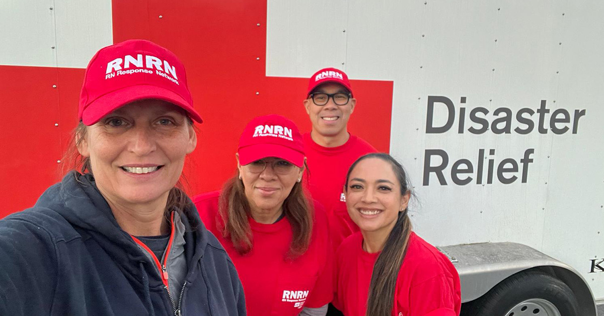 Four nurses in RNRN hats and shirts, posing together, smiling.