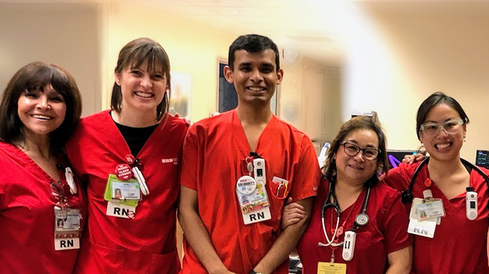 Five nurses side by side and smiling inside hospital