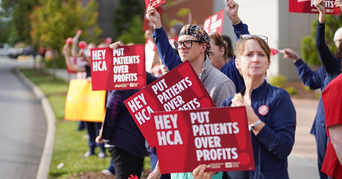 Nurses picketing outside Mission Hospital holding signs "Put Patients Over Profit"