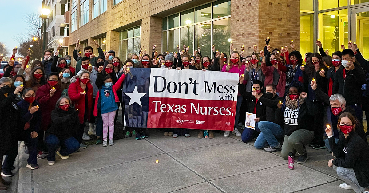 Large group of nurses outside hold sign "Don't mess with Texas nurses"