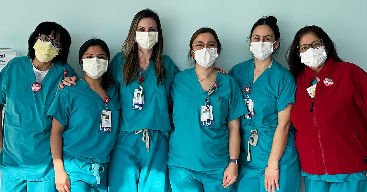Six nurses in scrubs posing for picture side by side