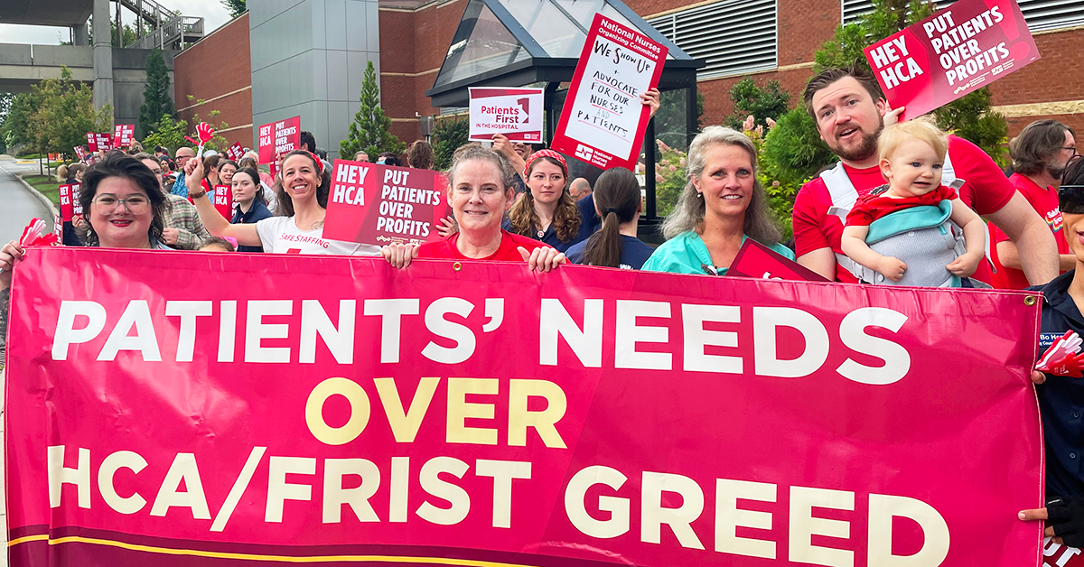 RNs at Mission Asheville holding signs and banner "Patients' needs over HCA/FRIST greed" and "Hey HCA, put patients over profits"