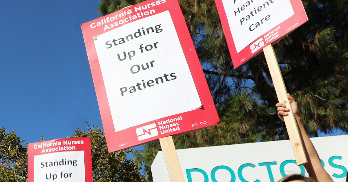 Signs held by Doctors Medical Center nurses: "Standing up for our patients"