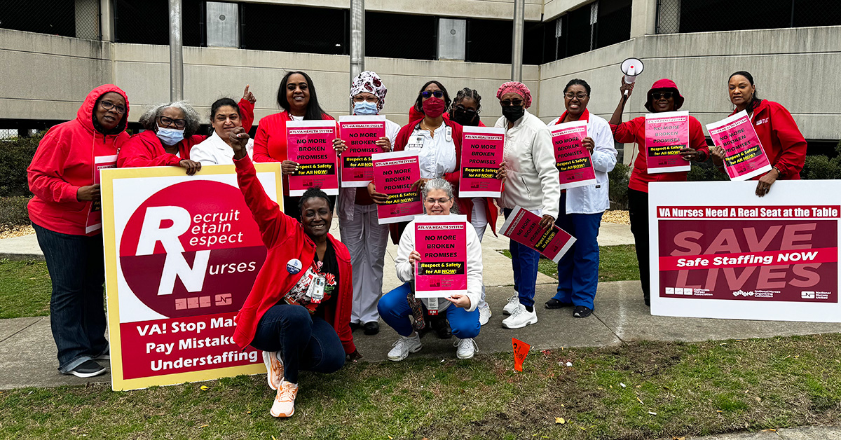 Large group of nurses dressed in red, outside hospital, holding signs "No More Broken Promises: Respect and Safety for All NOW"