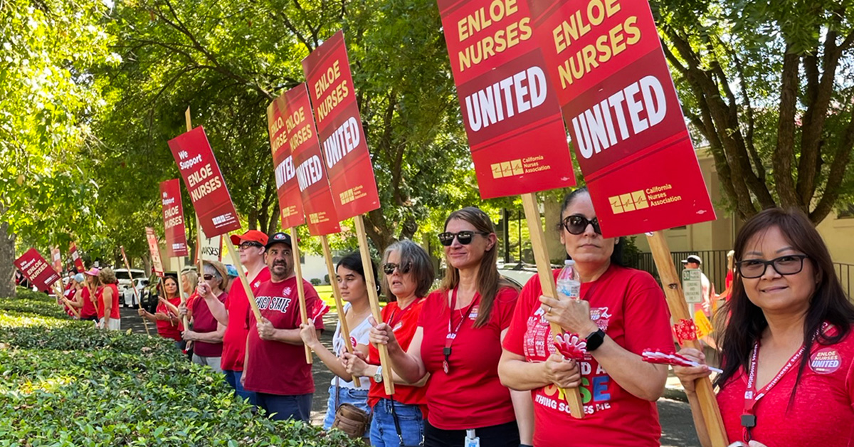 Nurses outside, holding signs "Enloe Nurses United"