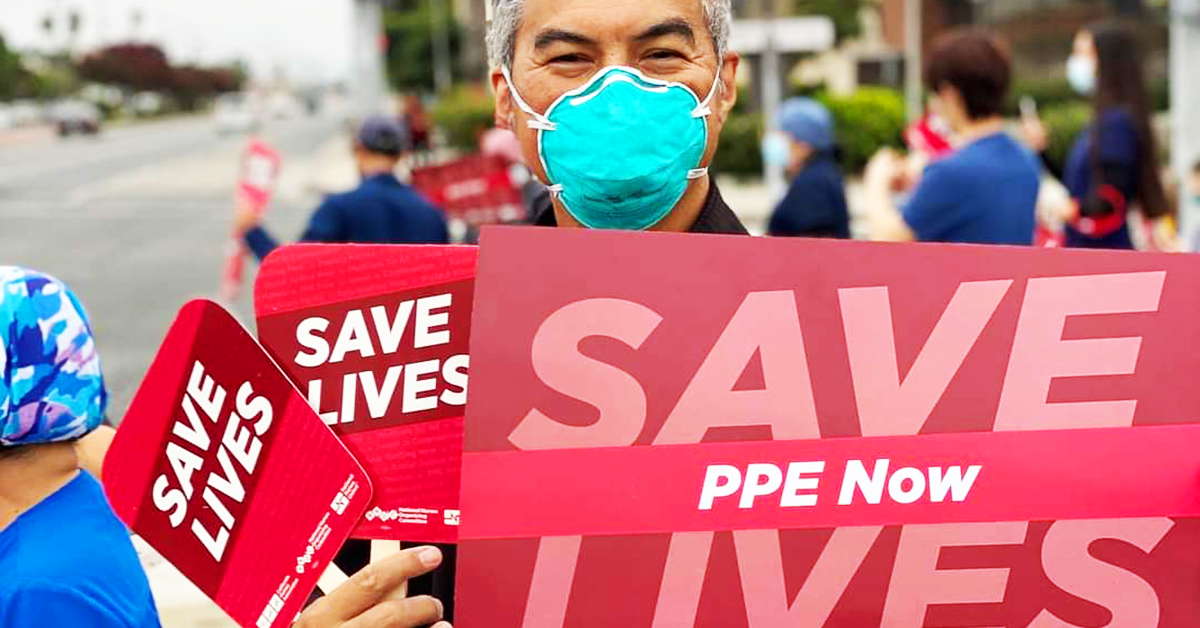 Nurse, masked holding signs "Save Lives: PPE Now"