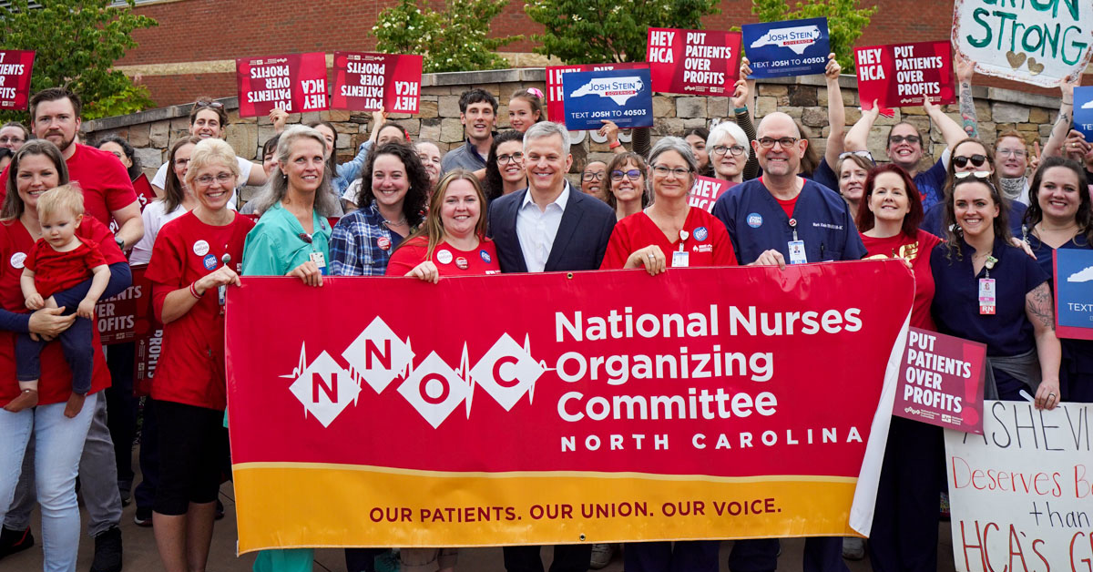 Large group of nurses standing with Josh Stein outside Mission Hospital holding an NNOC banner. Some hold signs "Josh Stein for Governor"