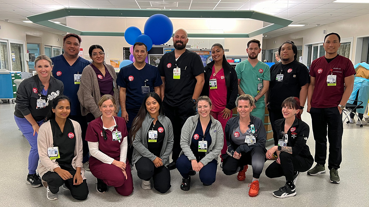 Large group of nurses inside hospital smiling.