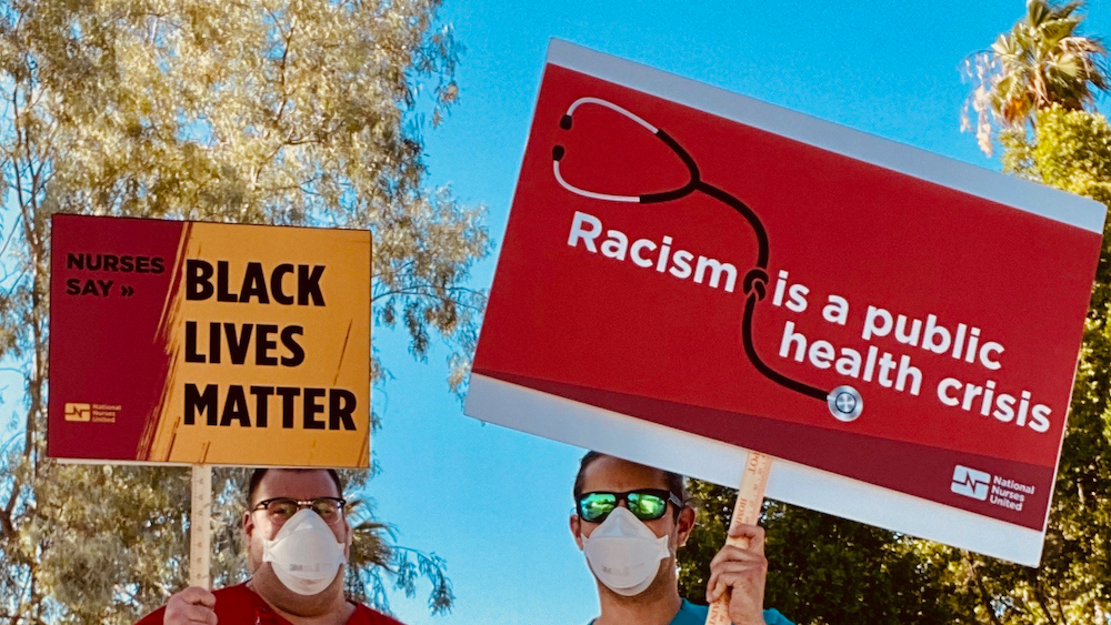 Nurses hold signs againt racism