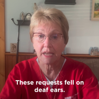 A photo of a middle aged nurse in a red scrub top talking to the camera