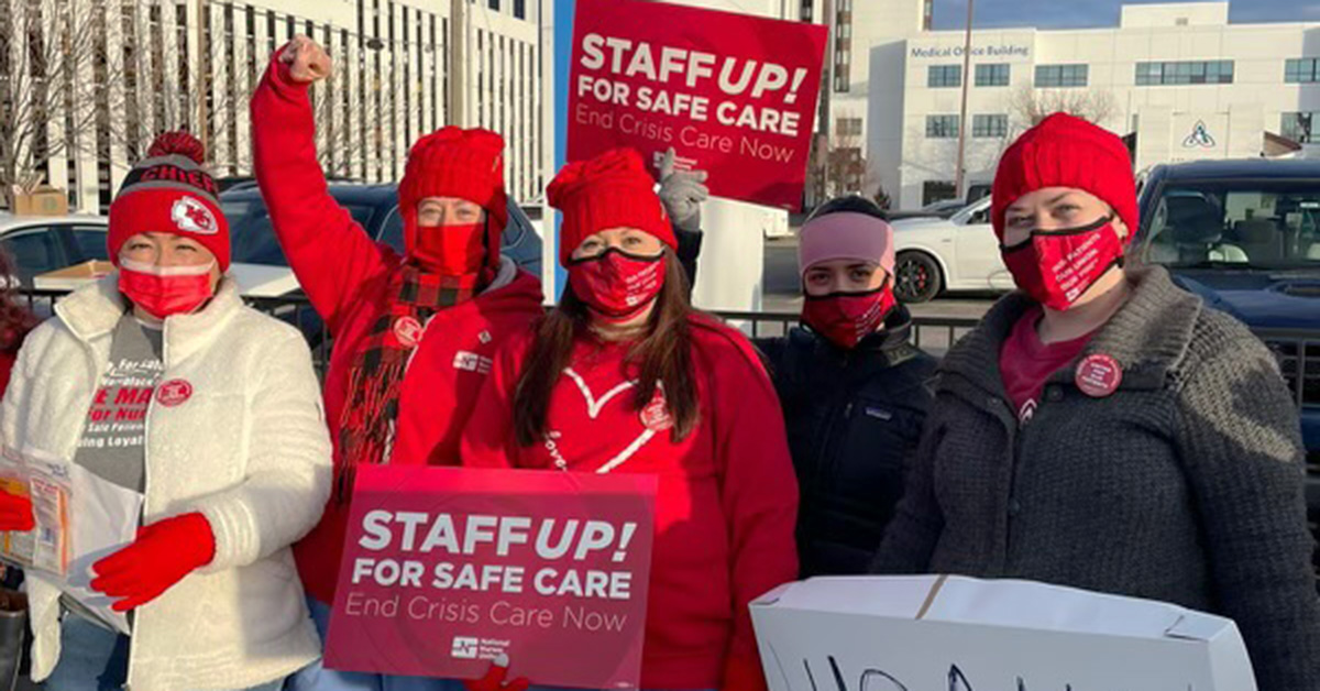 Nurses holding signs "Staff Up for Safe Care"