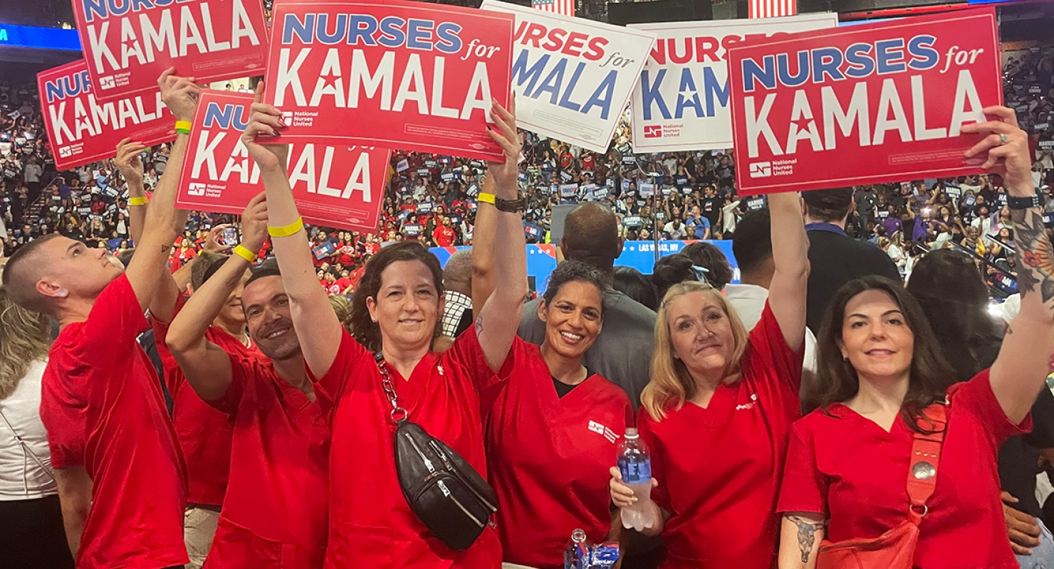 Group of nurses at rally holding signs "Nurses for Kamala"