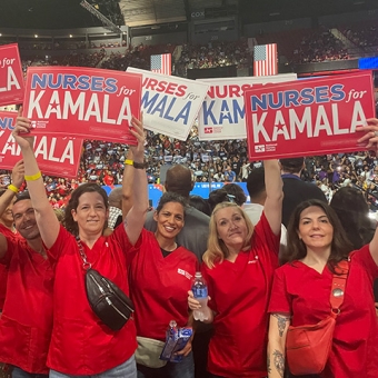 Group of nurses at rally holding signs "Nurses for Kamala"