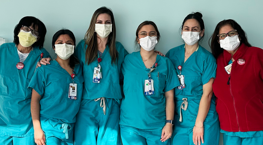 Six nurses in scrubs posing for picture side by side
