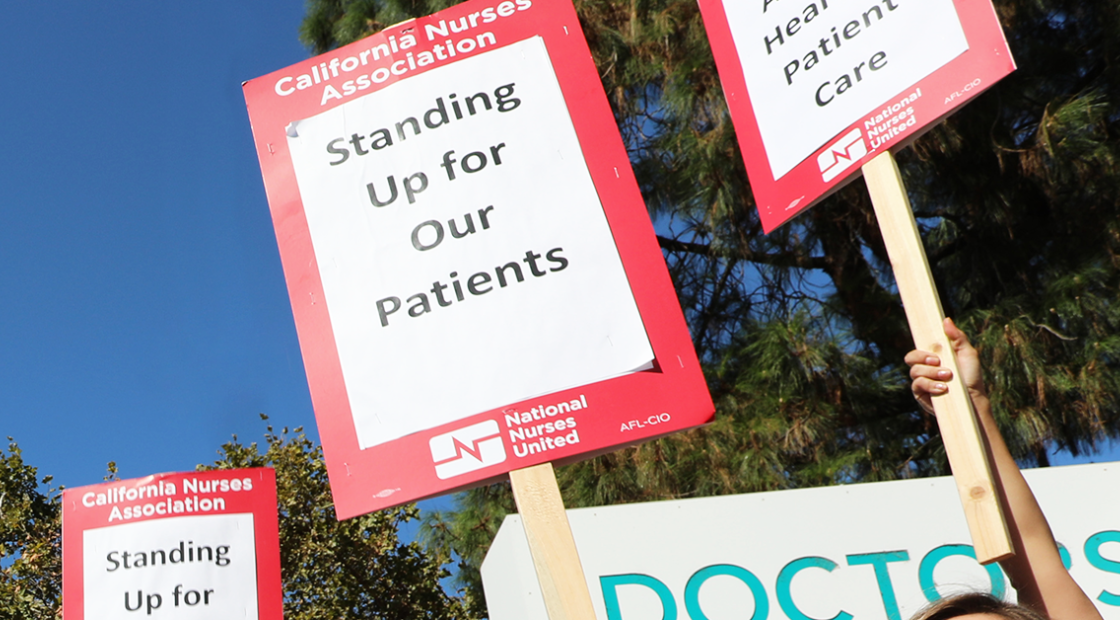 Signs held by Doctors Medical Center nurses: "Standing up for our patients"