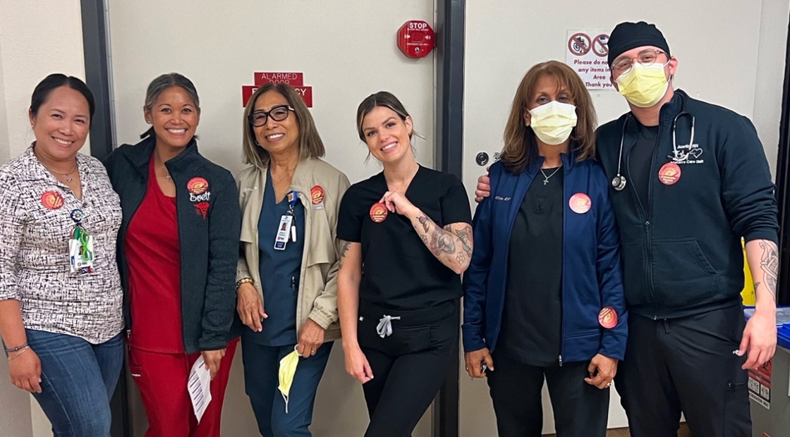 Group of six nurses inside hospital standing side-by-side