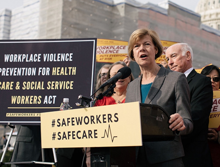 Sen. Tammy Baldwin in front of podium.