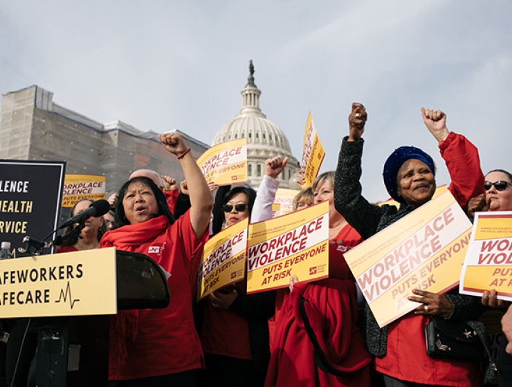 Nurses outside U.S. Capitol building with raised fists, holding signs calling for an end to workplace violence in health care settings