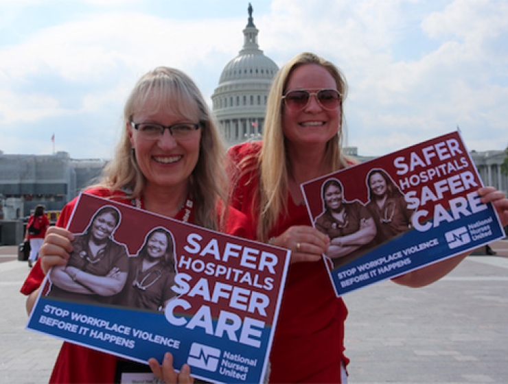 Two nurses holding signs "Safer Hospitals, Safer Care"