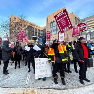 Group of nurses picketing outside of hospital, dressed for cold weather