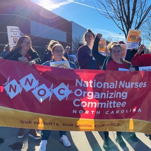 Group of nurses outside hospital holding banner "National Nurses Organizing Committee North Carolina"
