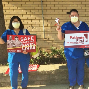 2 nurses outside hold signs "Patients First in the Hospital"