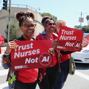 Two nurses holding signs "Trust Nurses Not A.I."