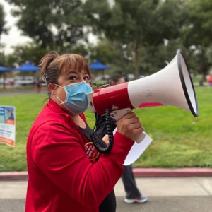 Masked nurse speaking into megaphone