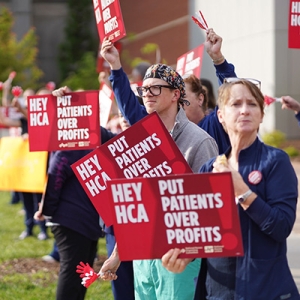 Nurses picketing outside Mission Hospital holding signs "Put Patients Over Profit"