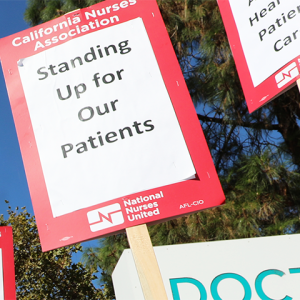 Signs held by Doctors Medical Center nurses: "Standing up for our patients"