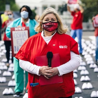 Nurses at National Day of Remembrance standing among over 400 pairs of white shoes in front of capitol building.