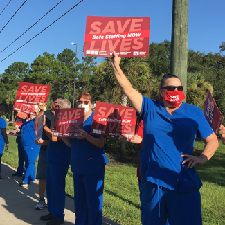 Nurses hold signs calling for safe staffing