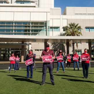 Nurses outside UC Davis Medical Center hold signs calling for safety measures